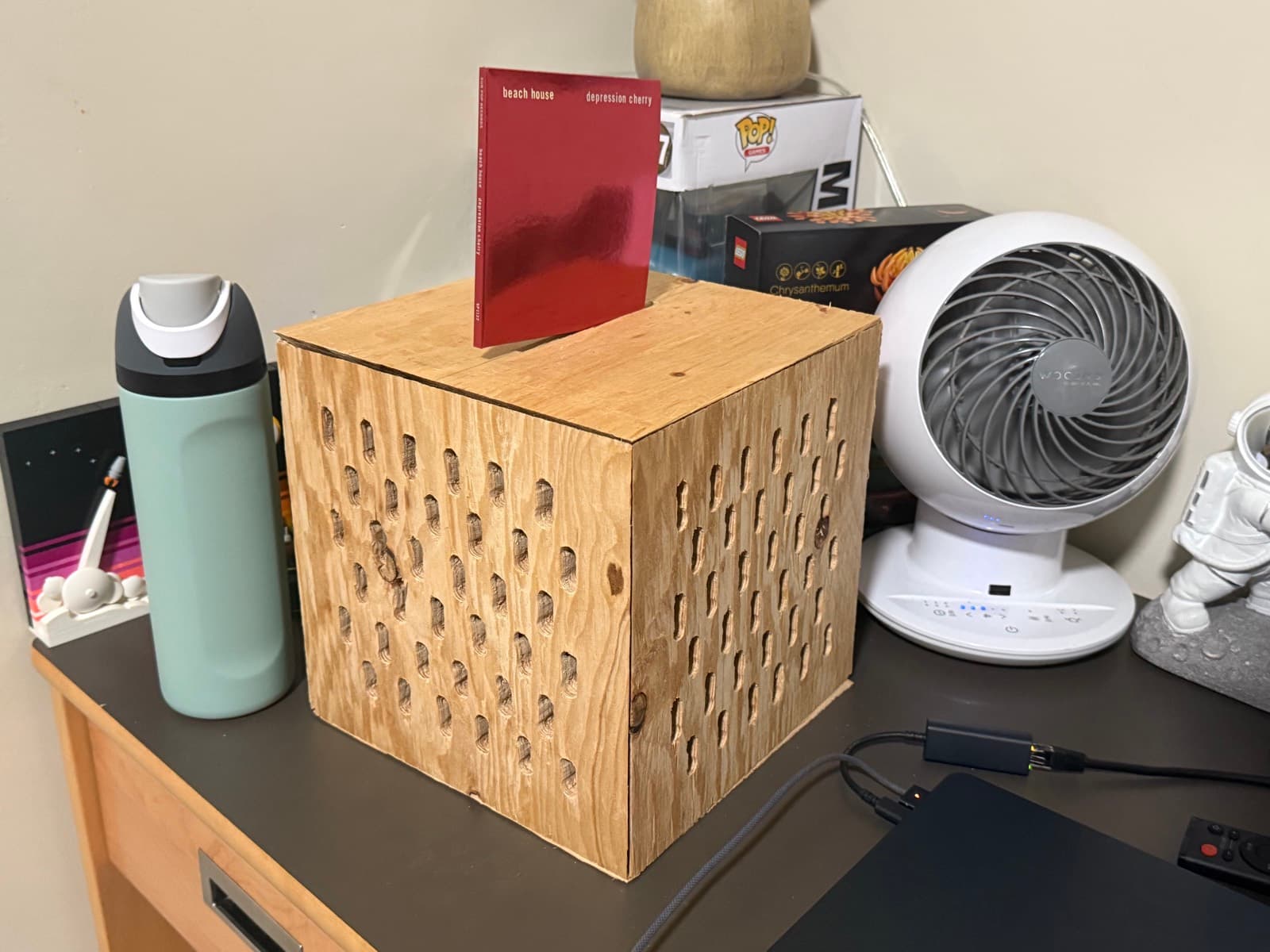 The jukebox — plywood v1 housing with carved note pattern, CD loaded through the top